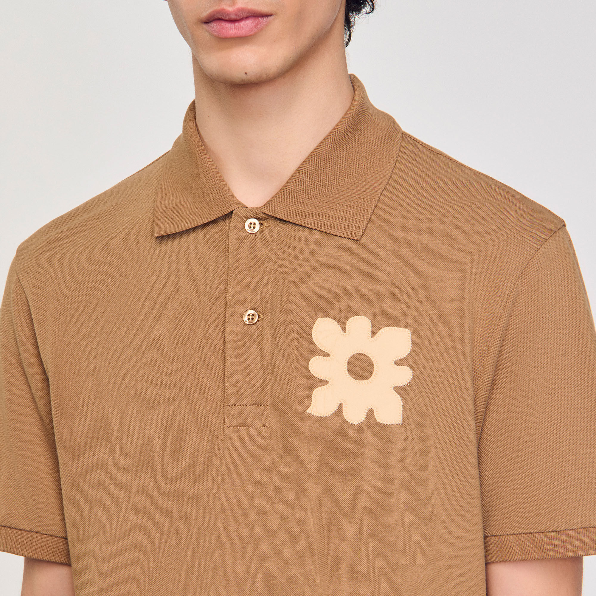 Polo con parche de flor